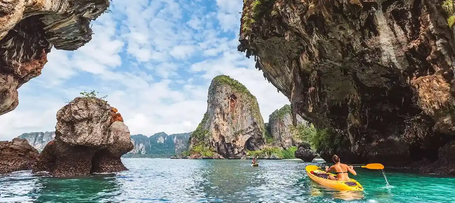 Kayakers explore rock formations and clear waters in Phuket's stunning landscape.