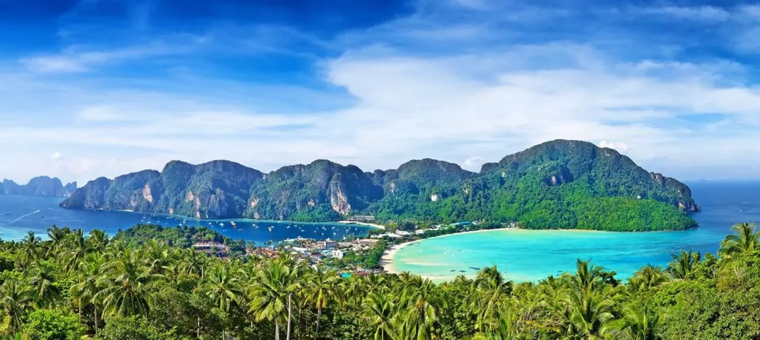 A panoramic view of lush greenery and turquoise waters in Phuket, Thailand.