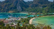 Scenic view of Phuket’s coastline with boats, greenery, and mountains in the background.