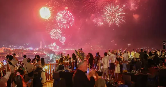 Фейерверк над Пхукетом на фоне вечеринки с людьми и столами. Сияние огней.