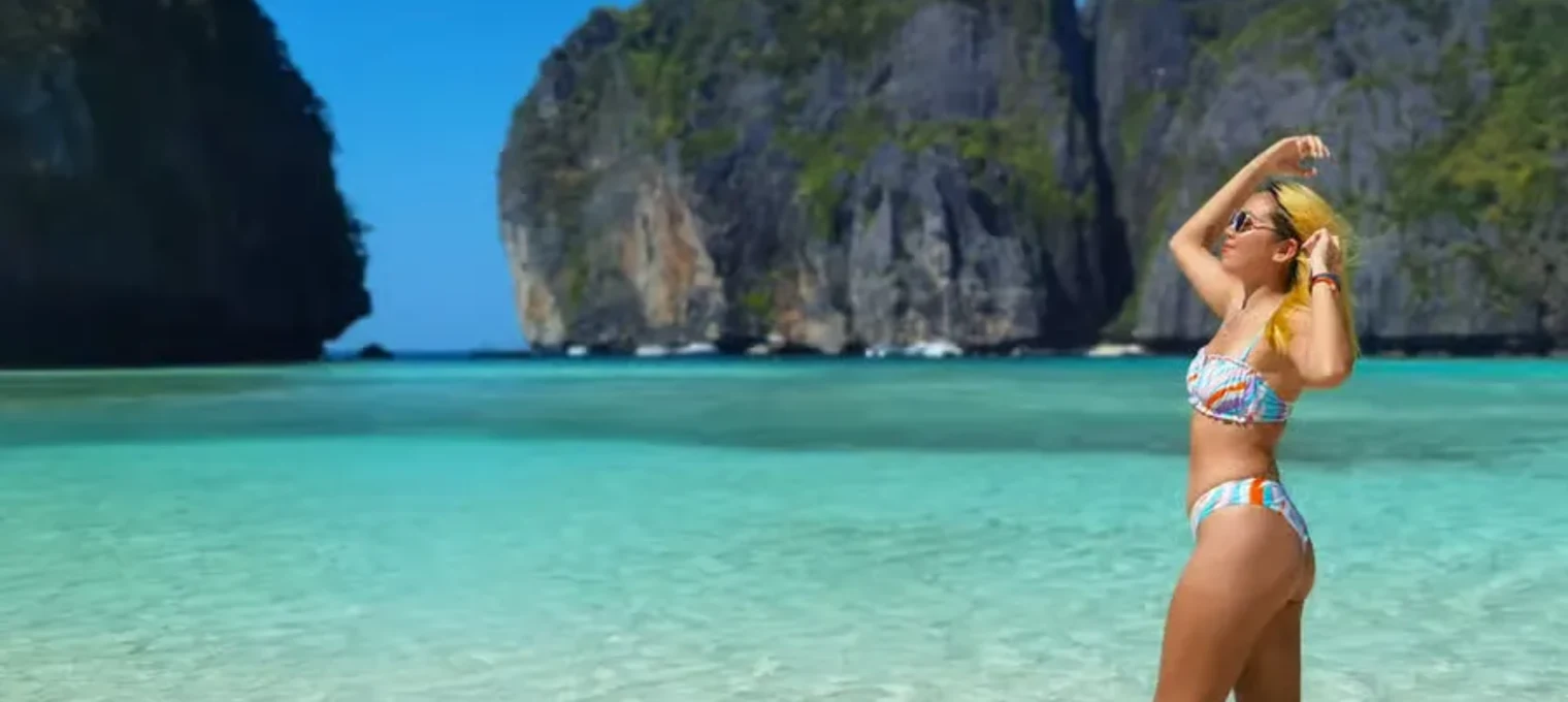 Woman in a colorful bikini enjoying a sunny day at a beach in Phuket, Thailand.