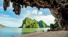 Scenic view of limestone cliffs and lush greenery over calm water in Phuket.