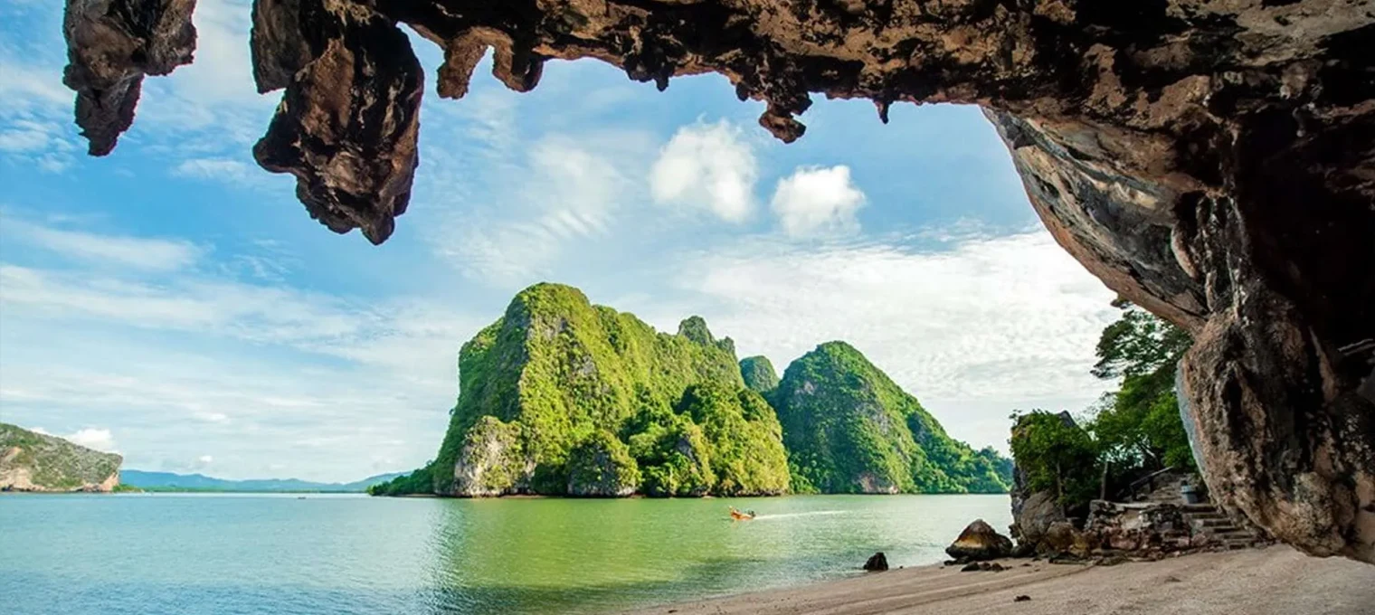 Scenic view of limestone cliffs and lush greenery over calm water in Phuket.