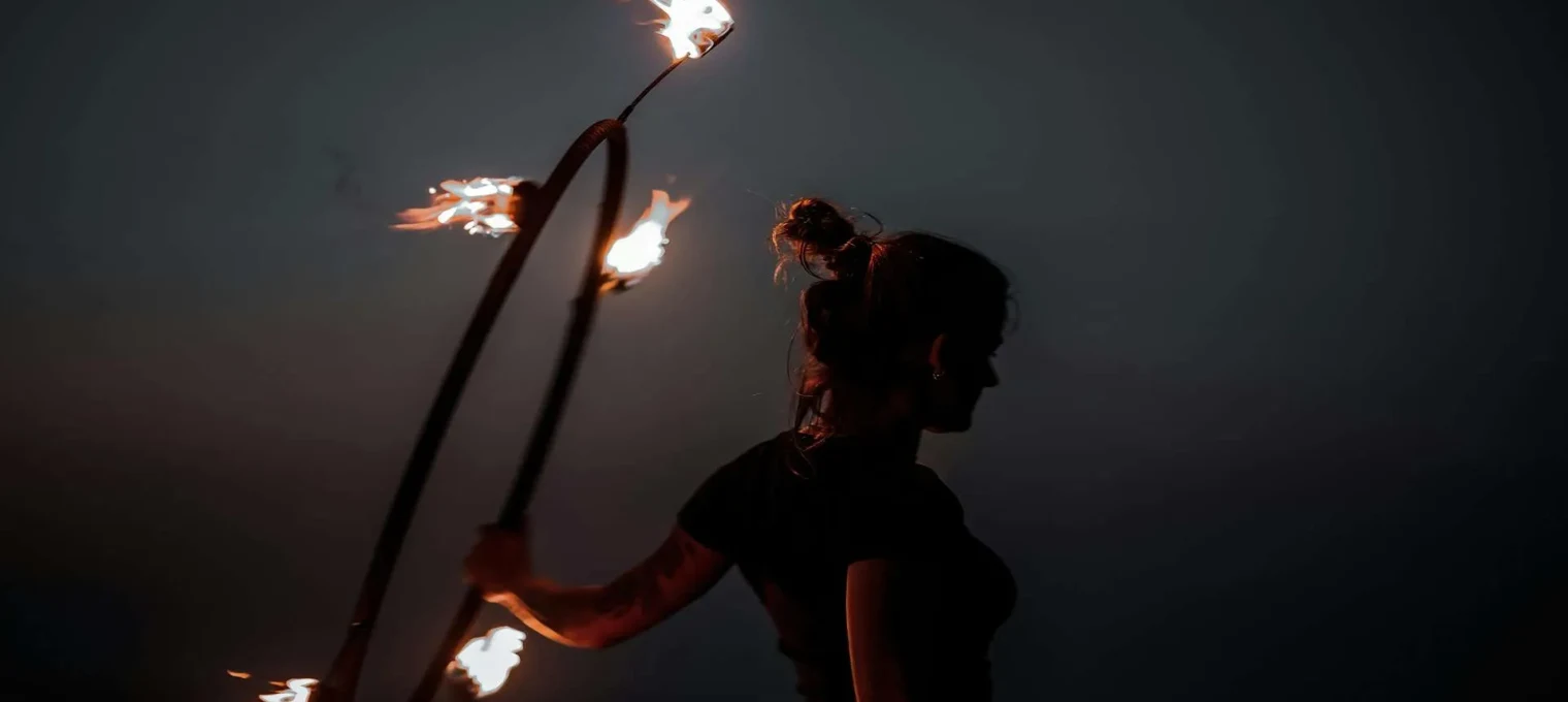 A person performing with flaming hula hoops against a dark sky in Phuket.