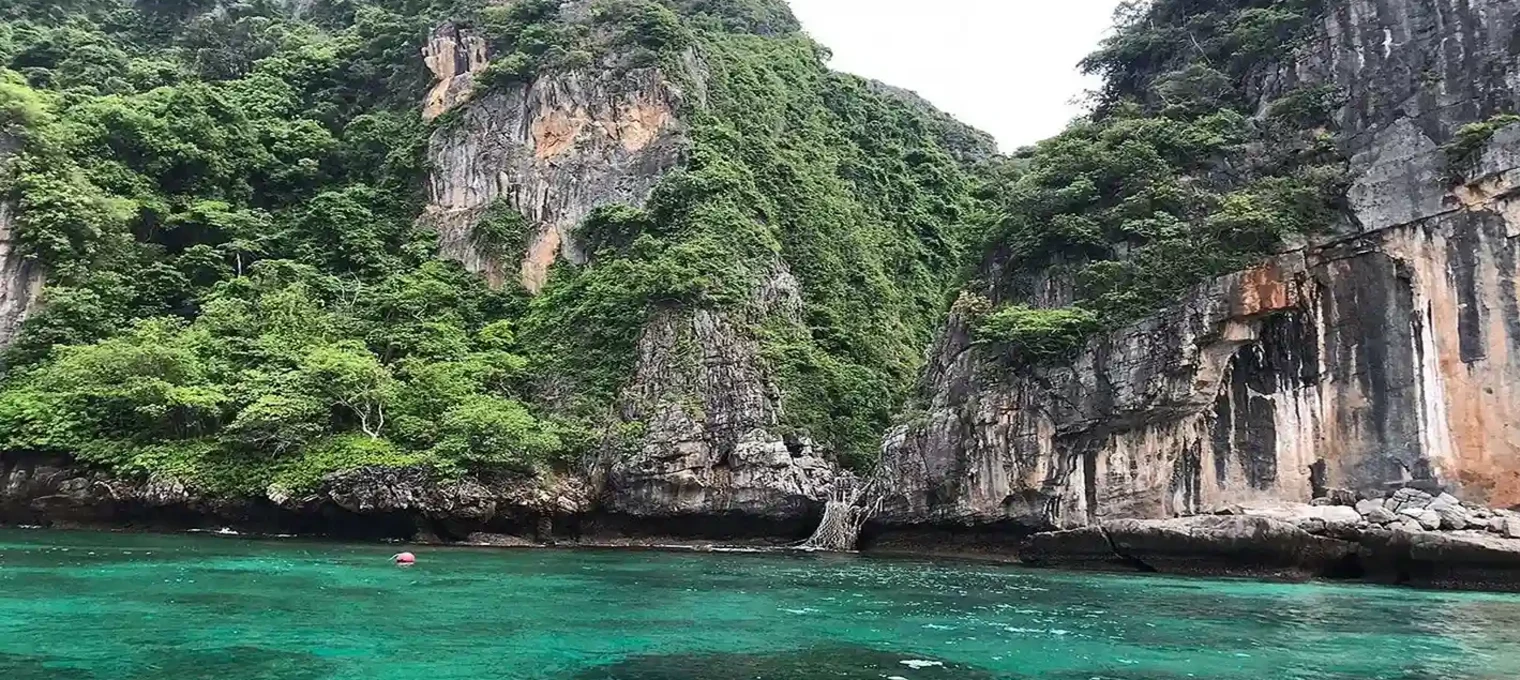 Scenic view of lush cliffs and turquoise waters in Phuket, Thailand.
