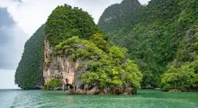Lush green island surrounded by turquoise waters in Phuket, Thailand.