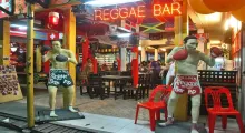 Two boxing statues outside a reggae bar in Phuket, vibrant with colorful decor.