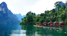 Scenic view of floating houses surrounded by lush greenery and mountains in Phuket, Thailand.