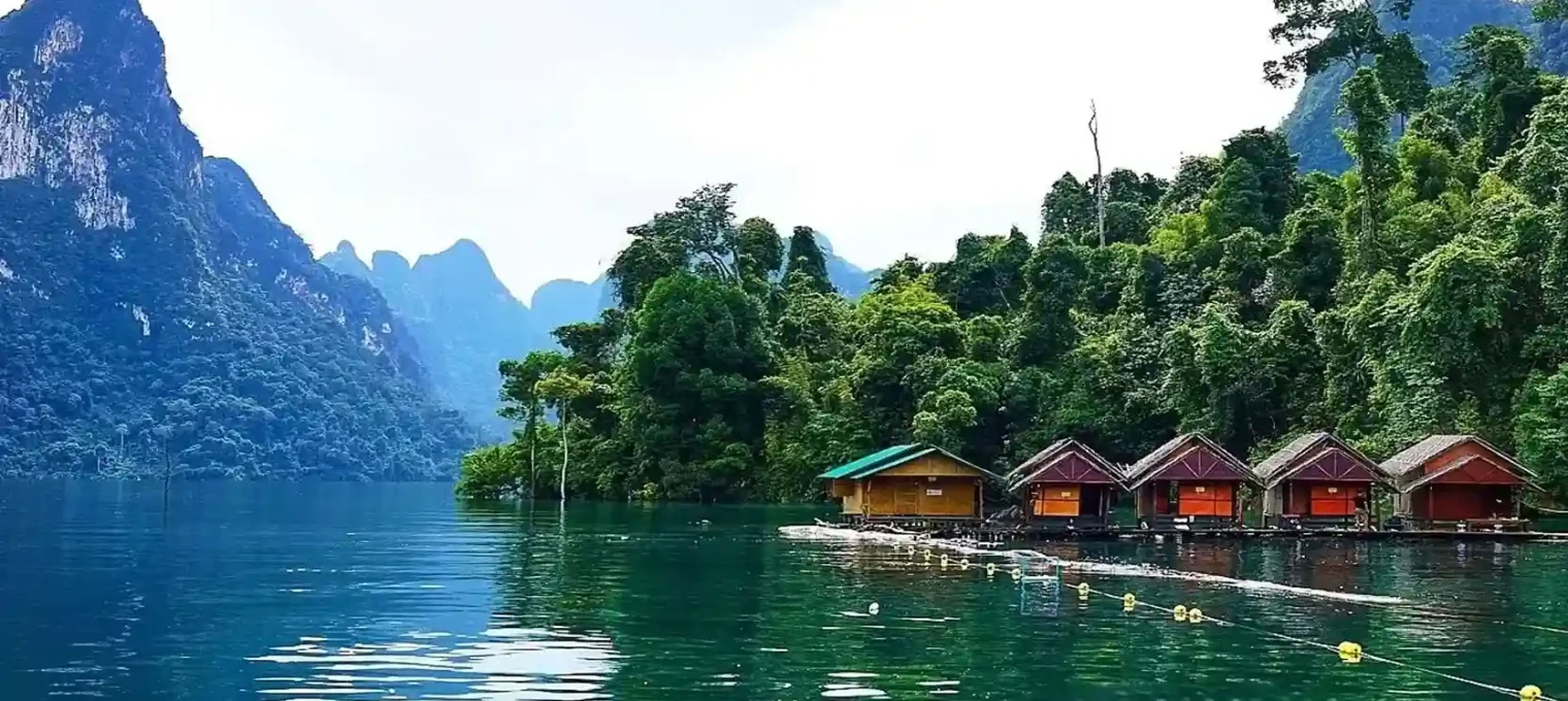 Scenic view of floating houses surrounded by lush greenery and mountains in Phuket, Thailand.