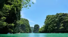 Serene view of turquoise waters surrounded by lush green cliffs in Phuket.