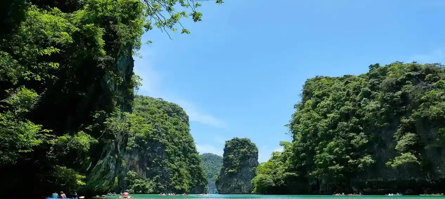 Serene view of turquoise waters surrounded by lush green cliffs in Phuket.